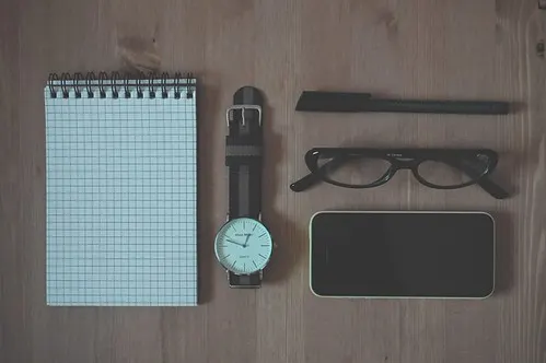 Phone and notebook beside a sports tracking page